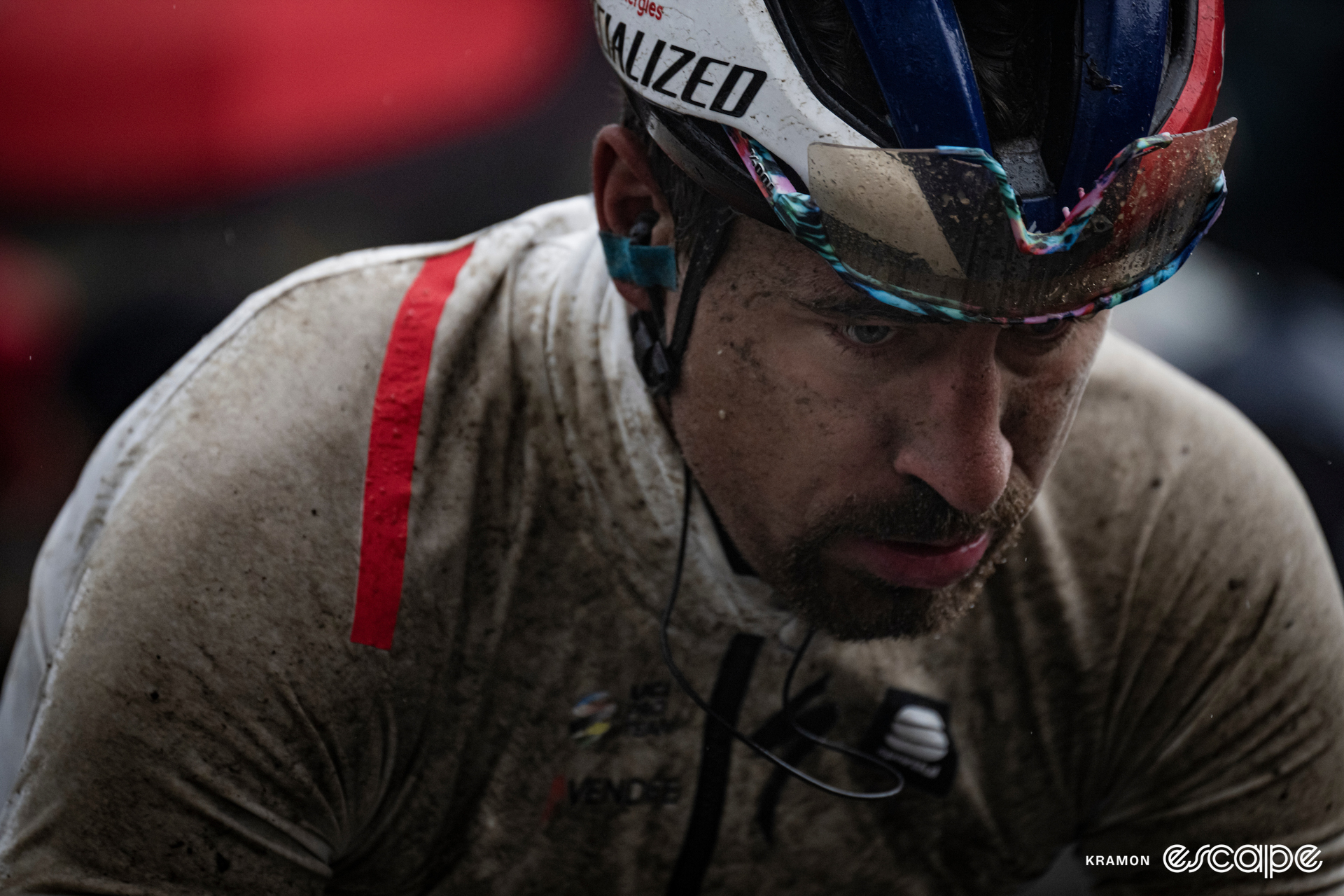 A forlorn-looking Peter Sagan looks towards the ground, covered in water and mud at the 2023 Gent-Wevelgem.