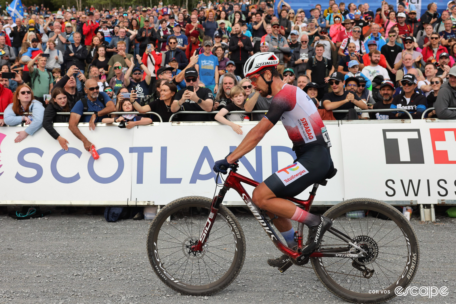 Peter Sagan sits on his mountain bike at the 2023 MTB Worlds in Glasgow with a large crowd behind him.
