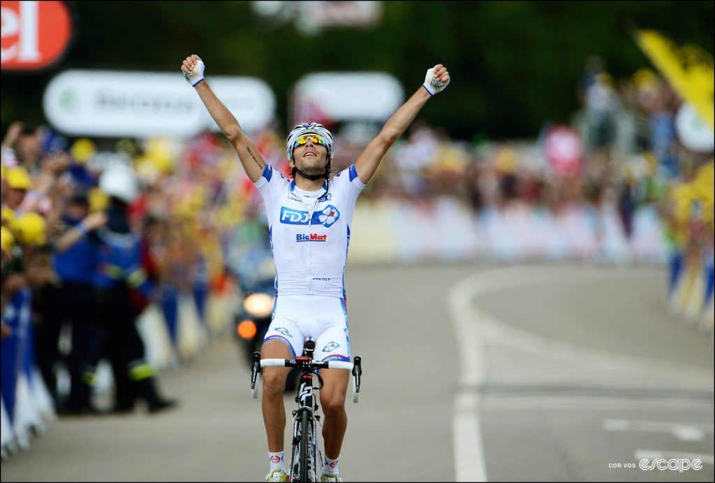 Thibaut Pinot lifts both arms in celebration after winning a stage of the Tour de France. 