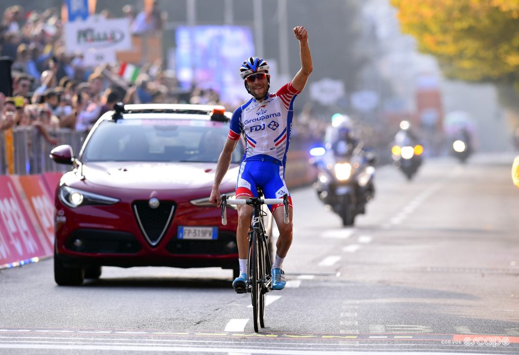 Thibaut Pinot raises a fist as he crosses the finish line at Il Lombardia. 