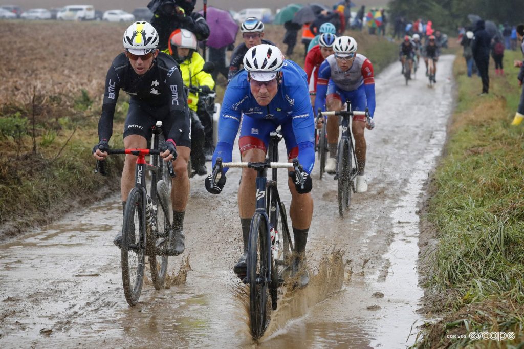 Stefan Küng splashes through a deep muddy puddle at Paris-Roubaix.