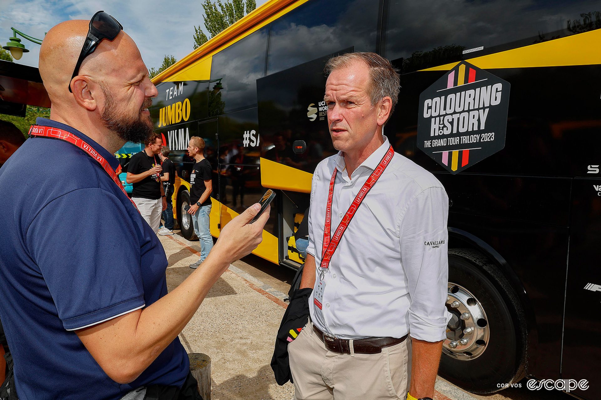 Jumbo-Visma manager RIchard Plugge speaks with a journalist outside the team bus at the 2023 Vuelta a España.
