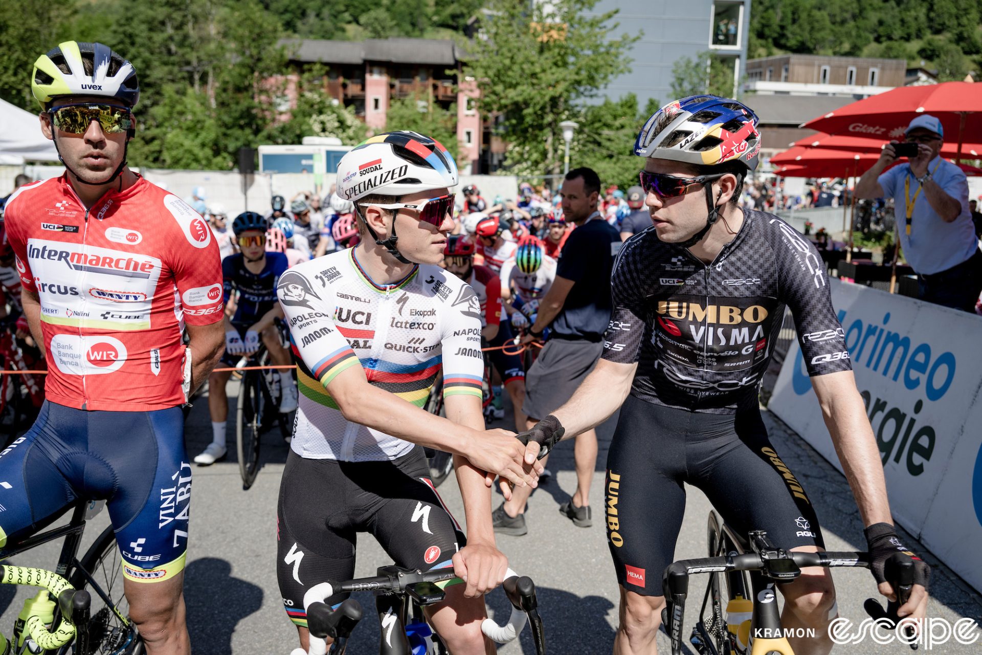 Remco Evenepoel and Wout van Aert shake hands at the start of a Tour de Suisse stage.