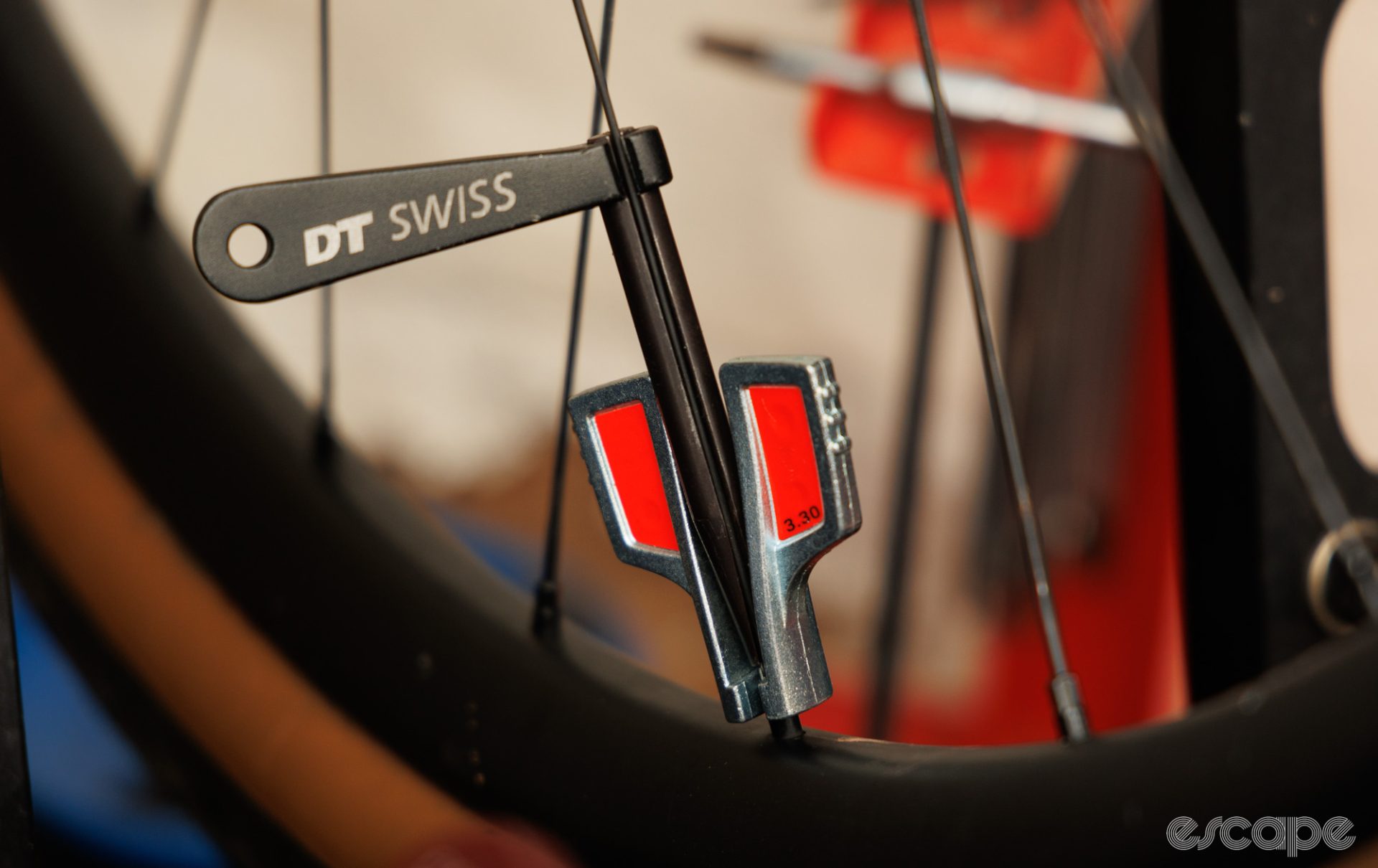 The Unior spoke key paired with a DT Swiss bladed spoke holder, all placed on a wheel. 