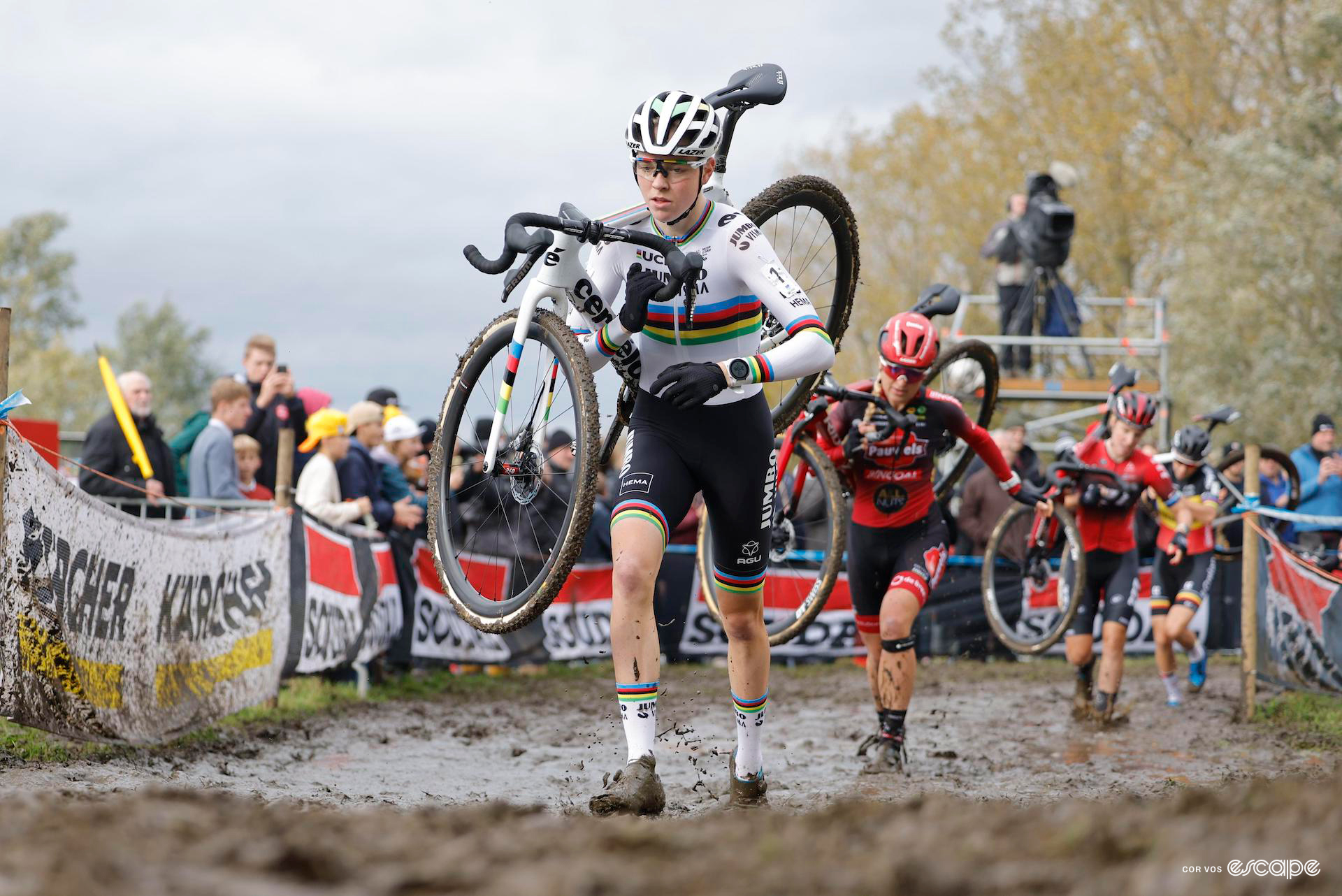 Fem van Empel leads the field through thick mud with her bike on her shoulder during Koppenbergcross.