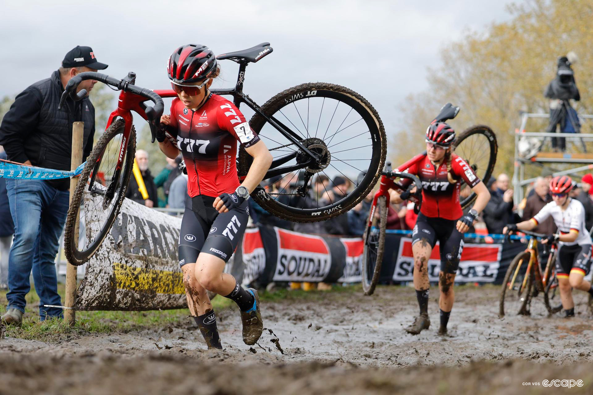 Anna Kay runs through thick mud with her bike on her shoulder during Koppenbergcross.