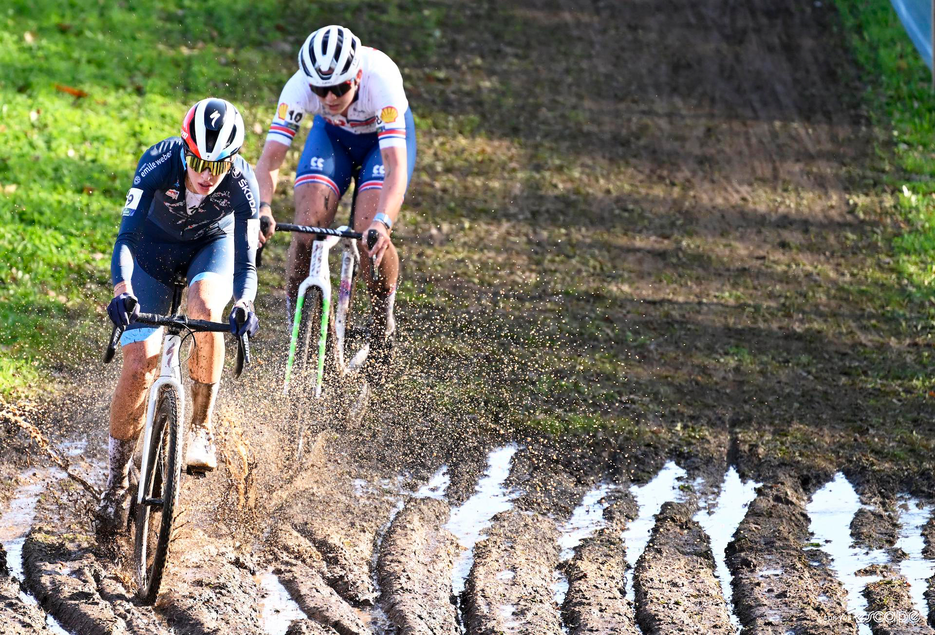 Marie Schreiber and Zoe Bäckstedt ride through heavily rutted mud as the sun shines on the women's under-23 cyclocross european championship race.