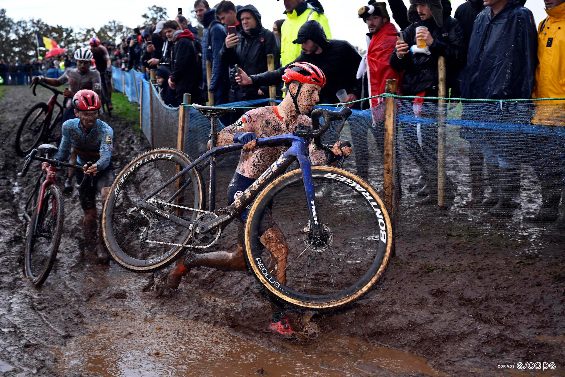 Lars van der Haar lifts his bike aloft as he runs through deep waterlogged mud during the european cyclocross champs.