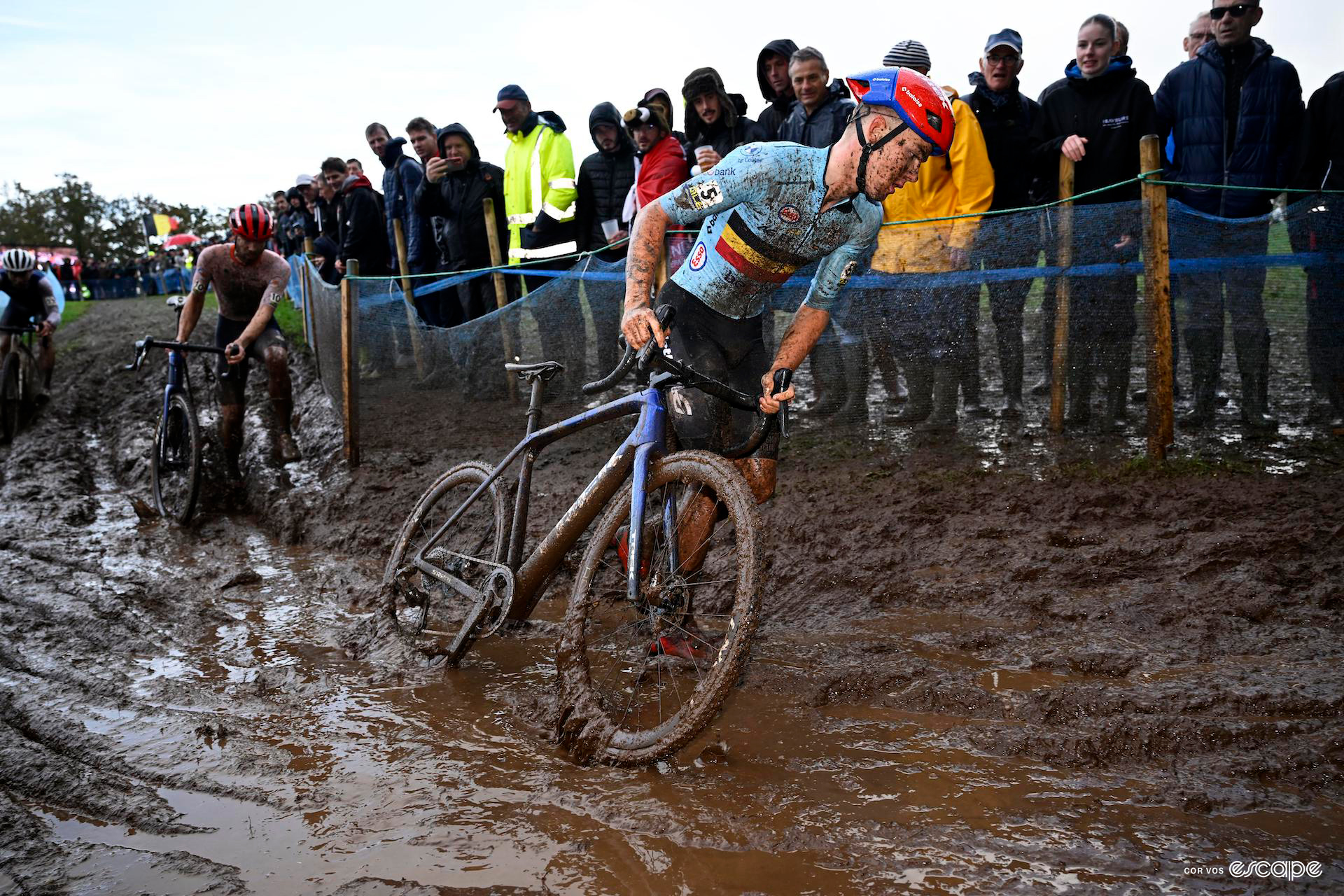 Thibau Nys drags his bike through thick waterlogged mud during the european cyclocross champs.