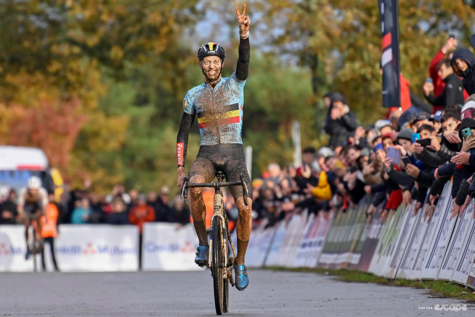 Michael Vanthourenhout sits up as he celebrates winning the european cyclocross title, two fingers raised to the sky.