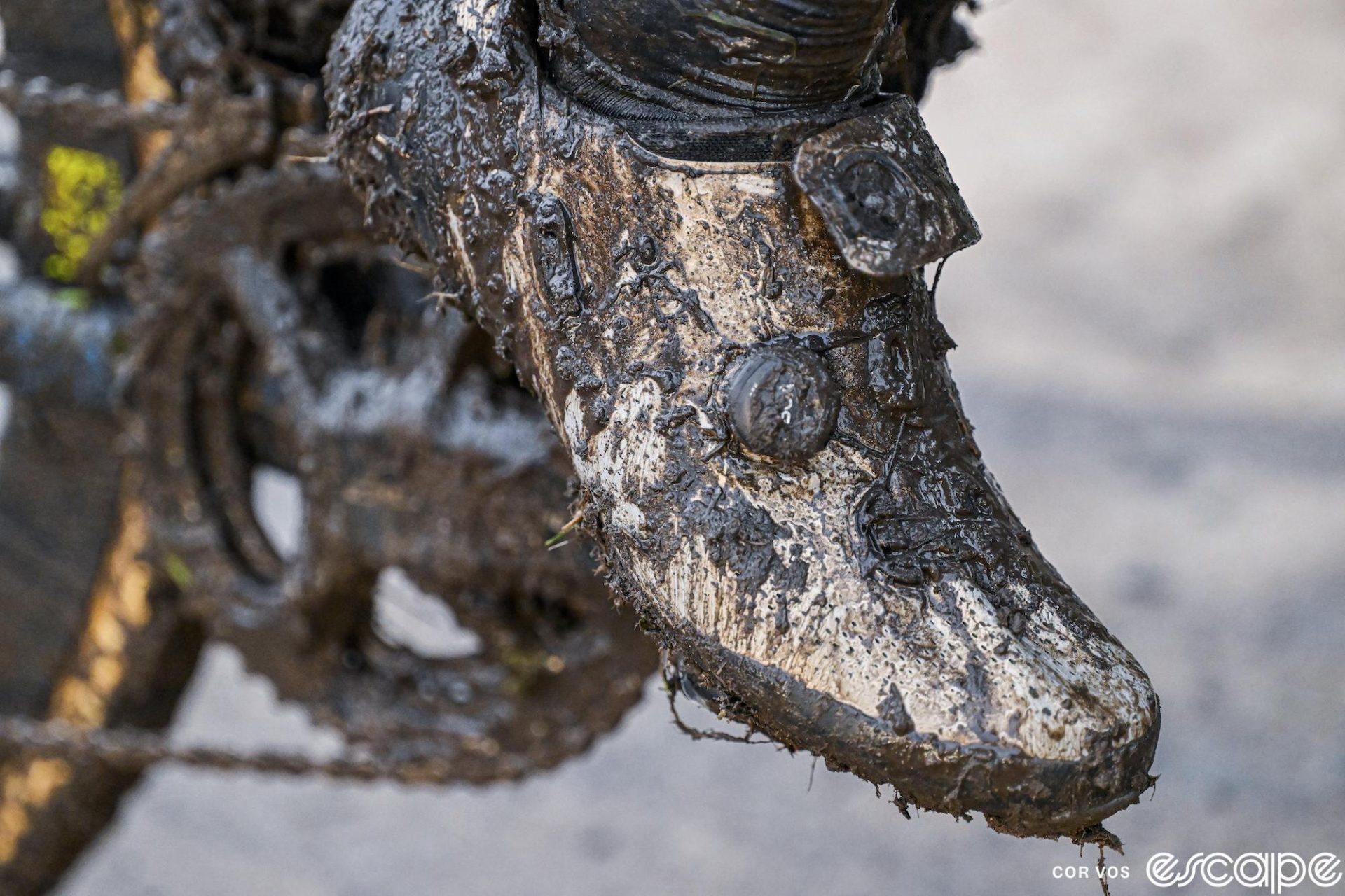 A closeup of a cyclocross shoe, covered in mud and missing one of its Boa closure dials.