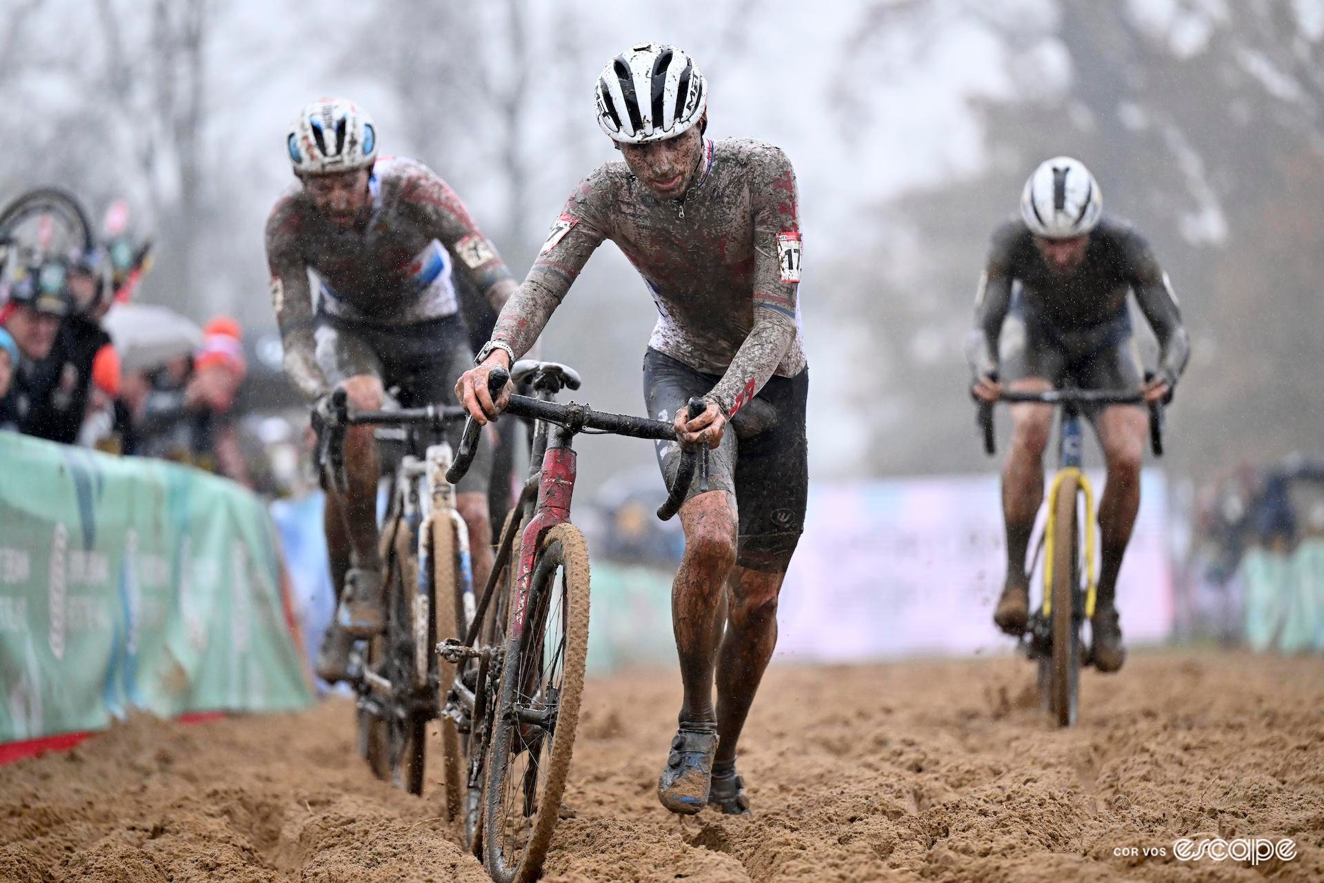 A dejected-looking Cameron Mason's white British national champion's jersey is almost completely covered in mud as he runs with his bike through the sandpit during CX World Cup Dublin.