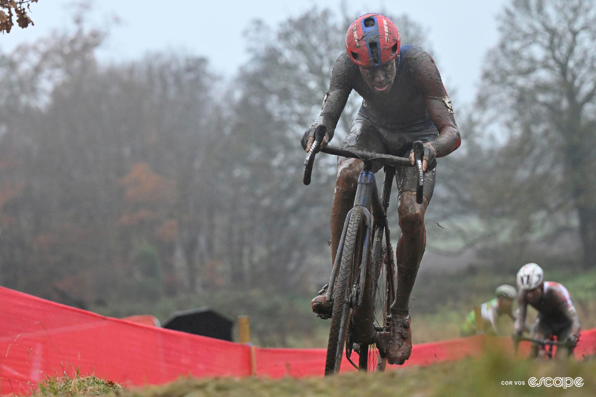 Head-on shot of Pim Ronhaar who is barely recognisable beneath the mud as he takes the lead in the final lap of CX World Cup Dublin, Eli Iserbyt and Laurens Sweeck just visible in pursuit.