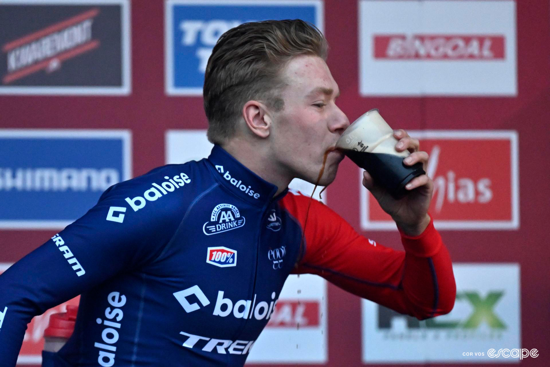Pim Ronhaar, cleaned and changed out of his muddy Baloise Trek Lions kit, spills some Guinness as he smiles through a celebratory pint on the podium after winning CX World Cup Dublin.