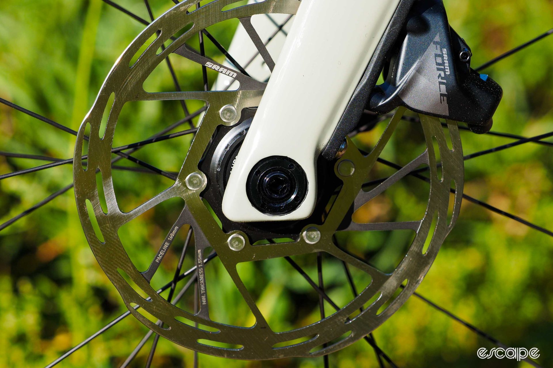 The through-axle and dropout of the fork, with a flat-mount SRAM Force caliper.