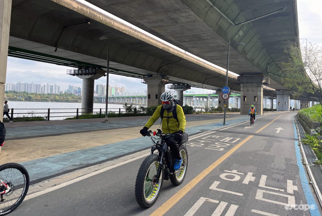 A man riding a fat tyre bike on a Seoul bike path.