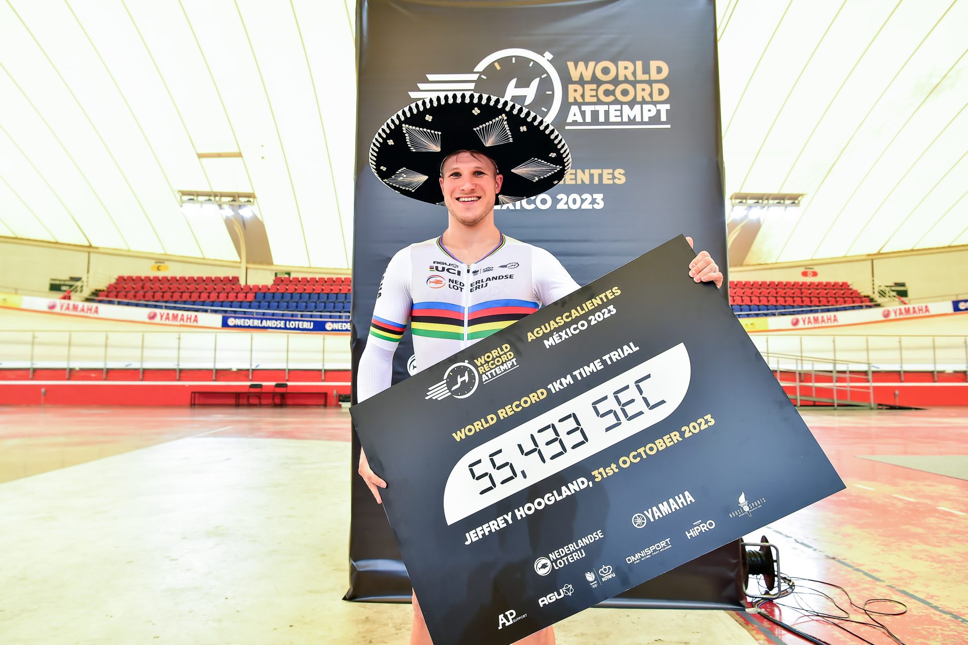 The photo shows Jeffrey Hoogland with a timing board showing his new a UCI Kilo world record of 55.433 seconds