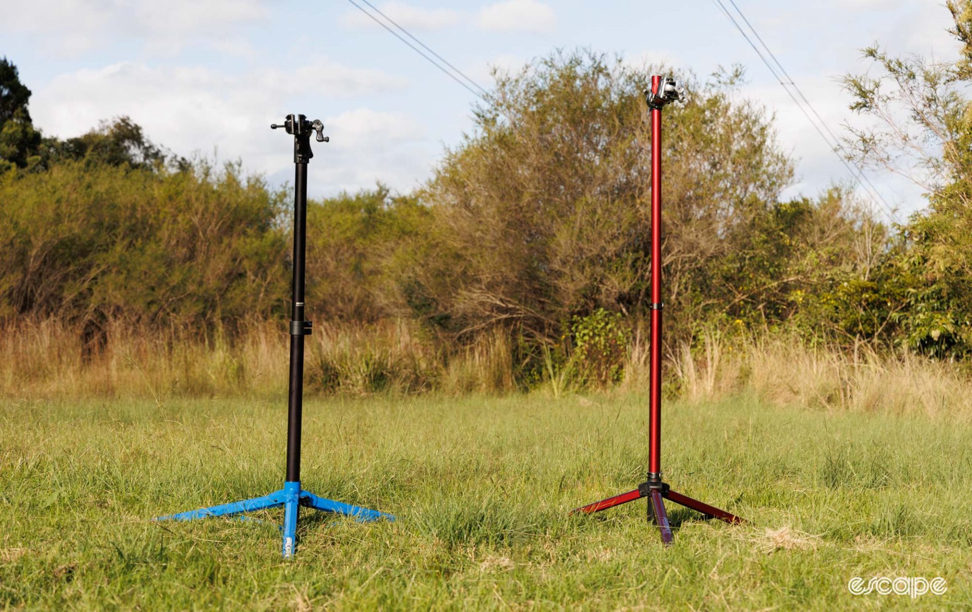 Park Tool PRS-26 and Feedback Sports Pro Mechanic repair stands in a grass field.  
