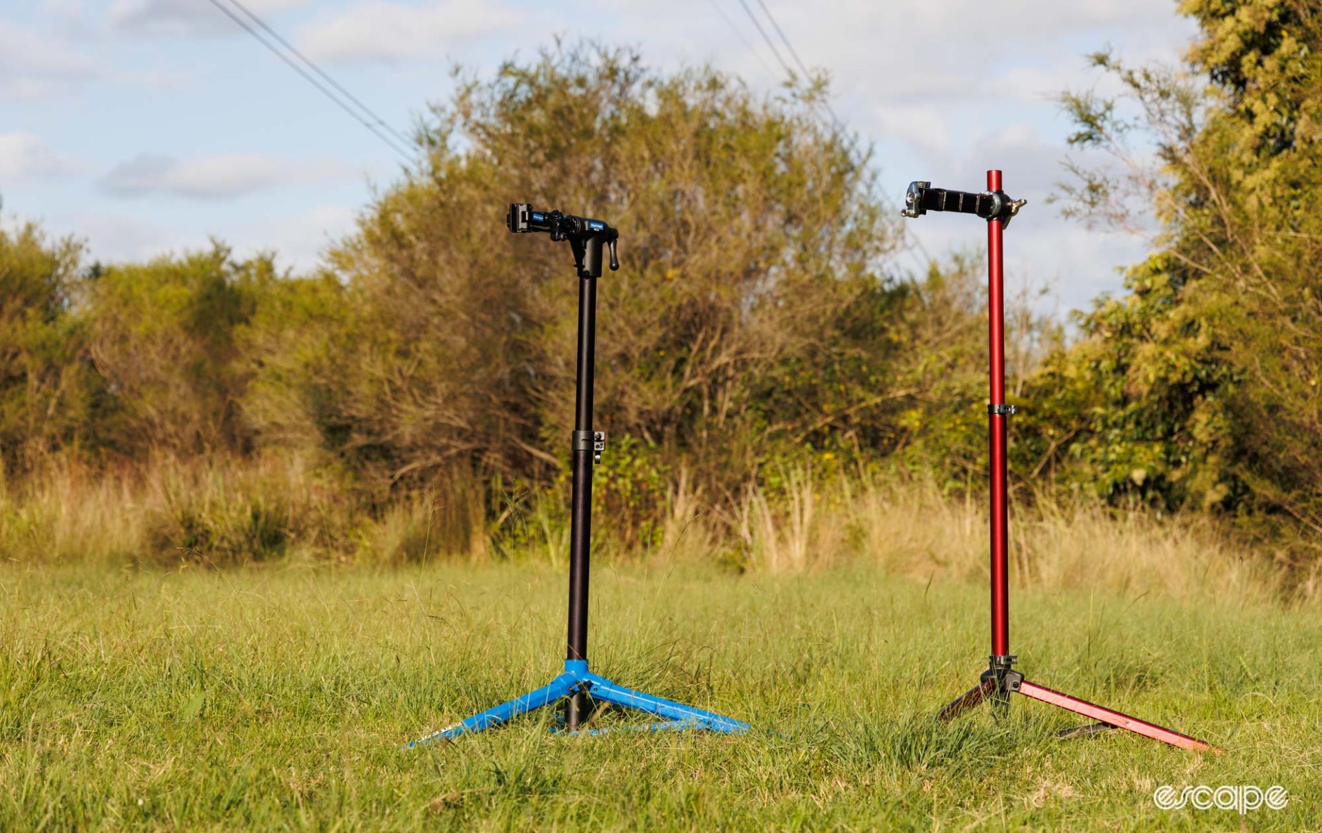 Park Tool PRS-26 and Feedback Sports Pro Mechanic repair stands in a grass field. 