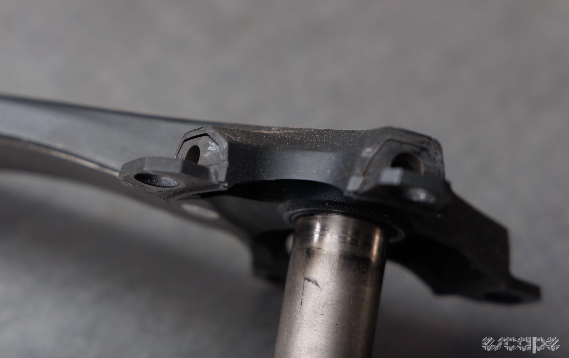A Shimano crankarm in closeup, showing separation in the bond seam at the drive-side crankarm spider. Several small but noticeable gaps can be seen.