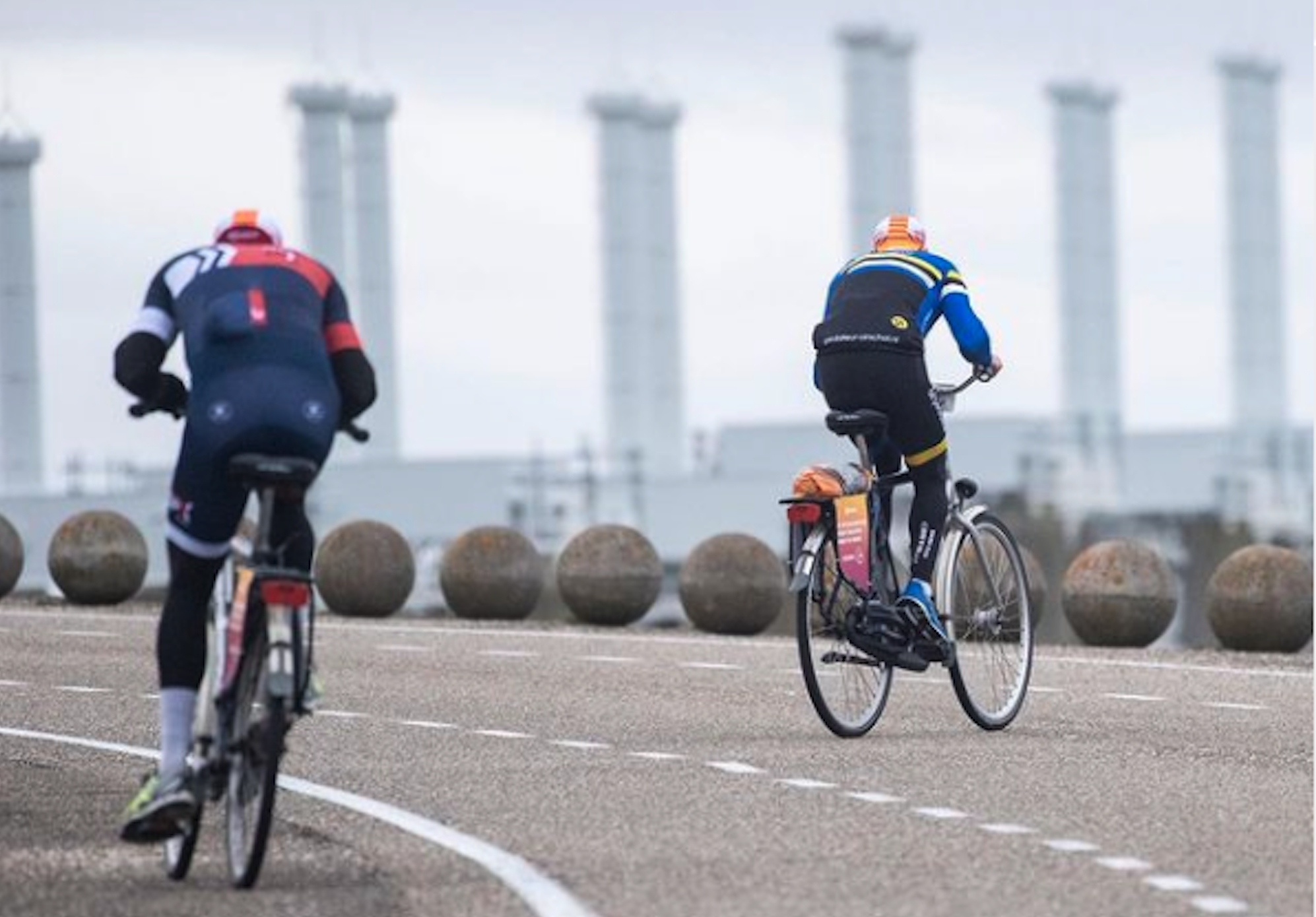 Riders struggle against a headwind on the Eastern Scheldt Storm Barrier during an edition of Tegenwindfietsen.