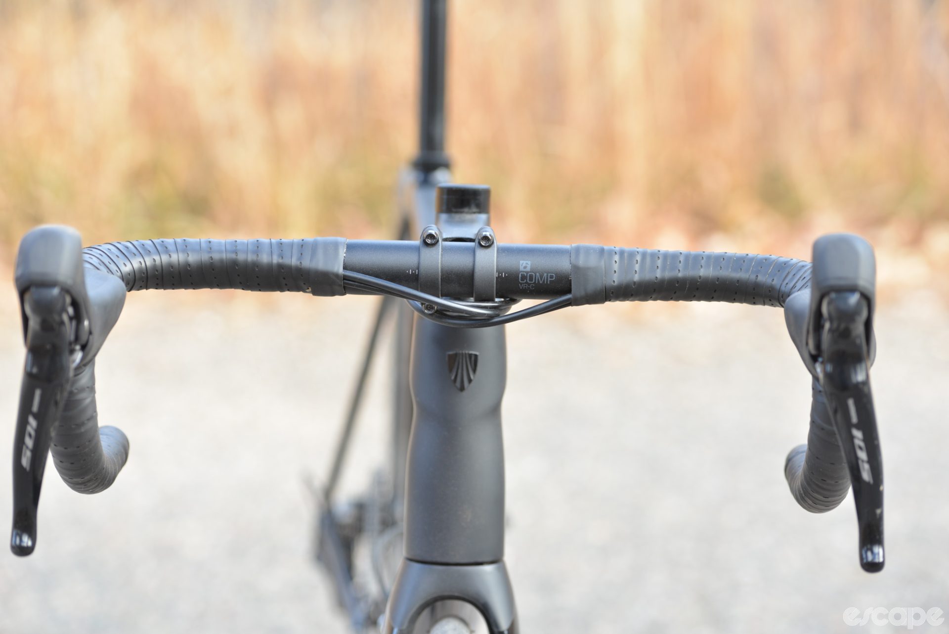The integrated front end of the Emonda ALR, showing the brake and derailleur housings exit the bar tape and slide under the stem to enter the bike at the front of the headset.