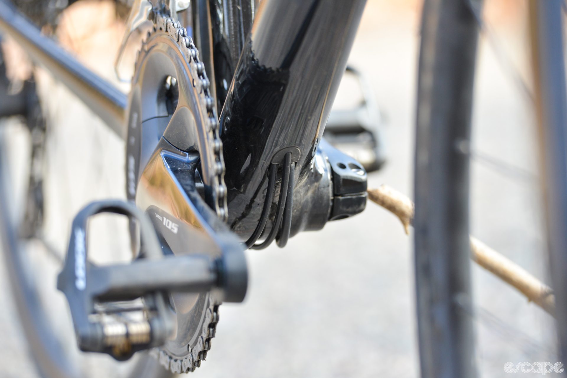 The internal cable routing at the bottom bracket, which shows both derailleur cables and the rear brake housing exit at a port just above the bottom bracket shell, then closely follow the shell before re-entering the frame.