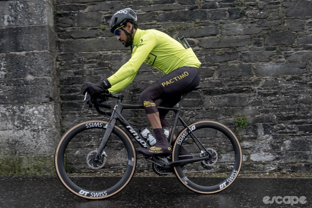Yakob Debesay riding along a stone wall on his FiftyOne bike. 