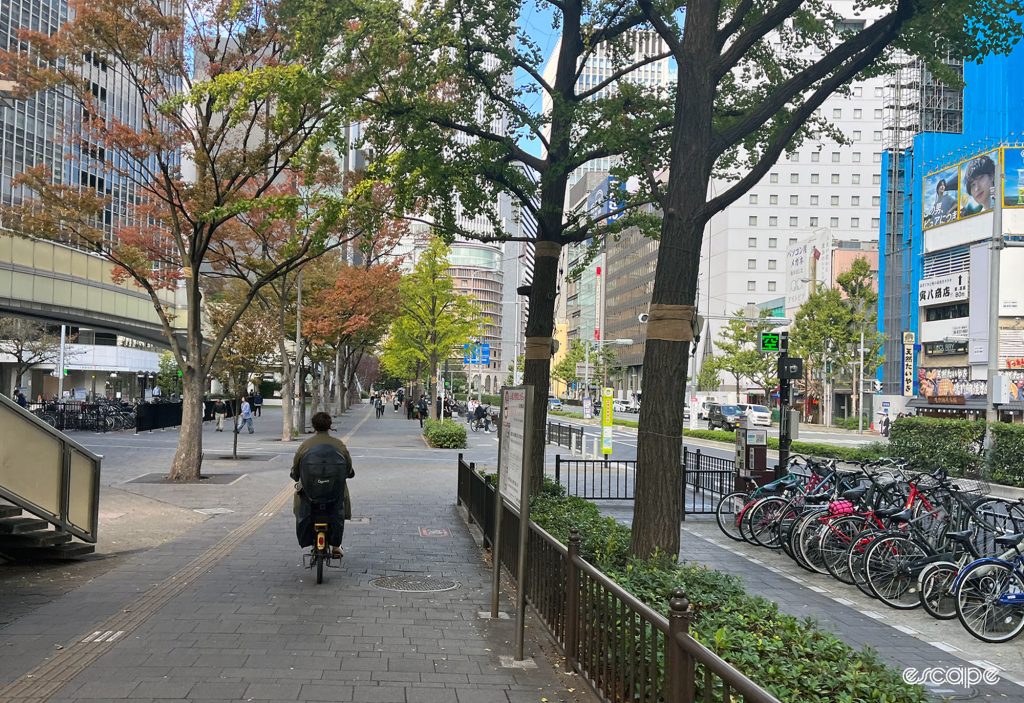 People cycling on the pavement in Osaka.
