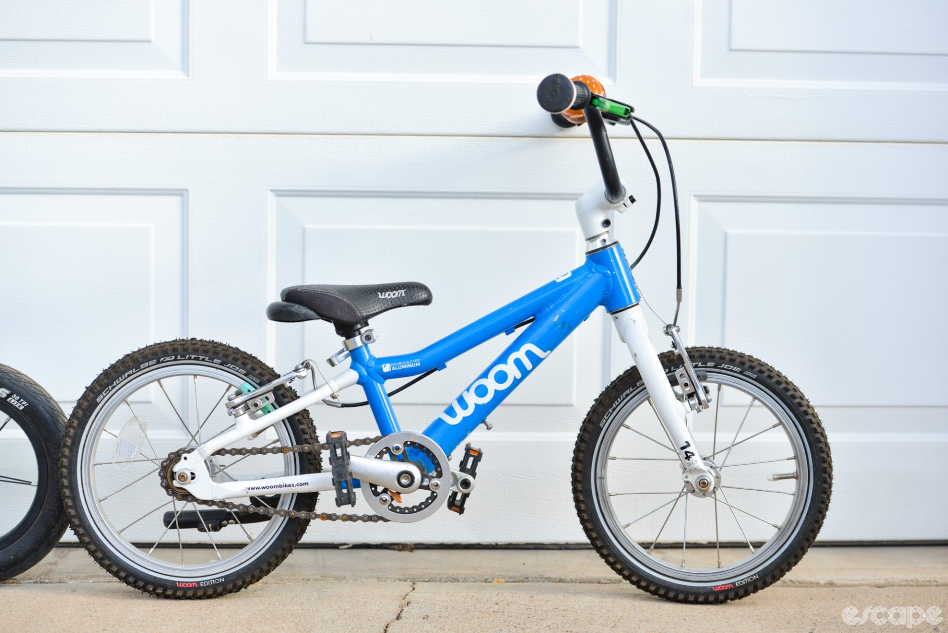 The Woom 2, with a lightweight but sturdy aluminum frame, hub-spoke-and-rim wheels with aired tires, and front and rear hand brakes. The handlebars are set tall for an upright position.