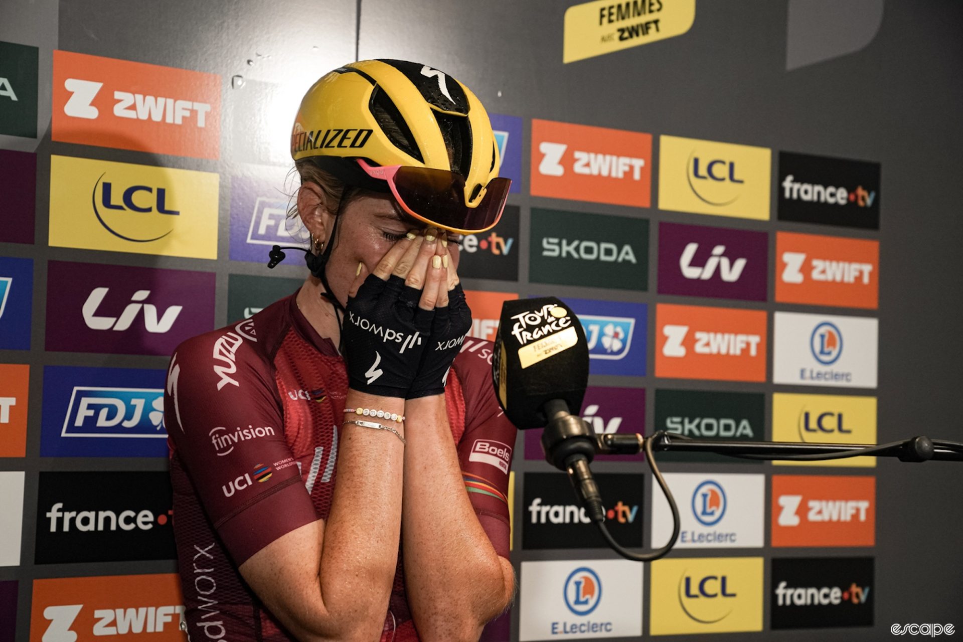 Demi Vollering holds her face in her hands during the post-win interview after the seventh stage of the Tour de France Femmes. 