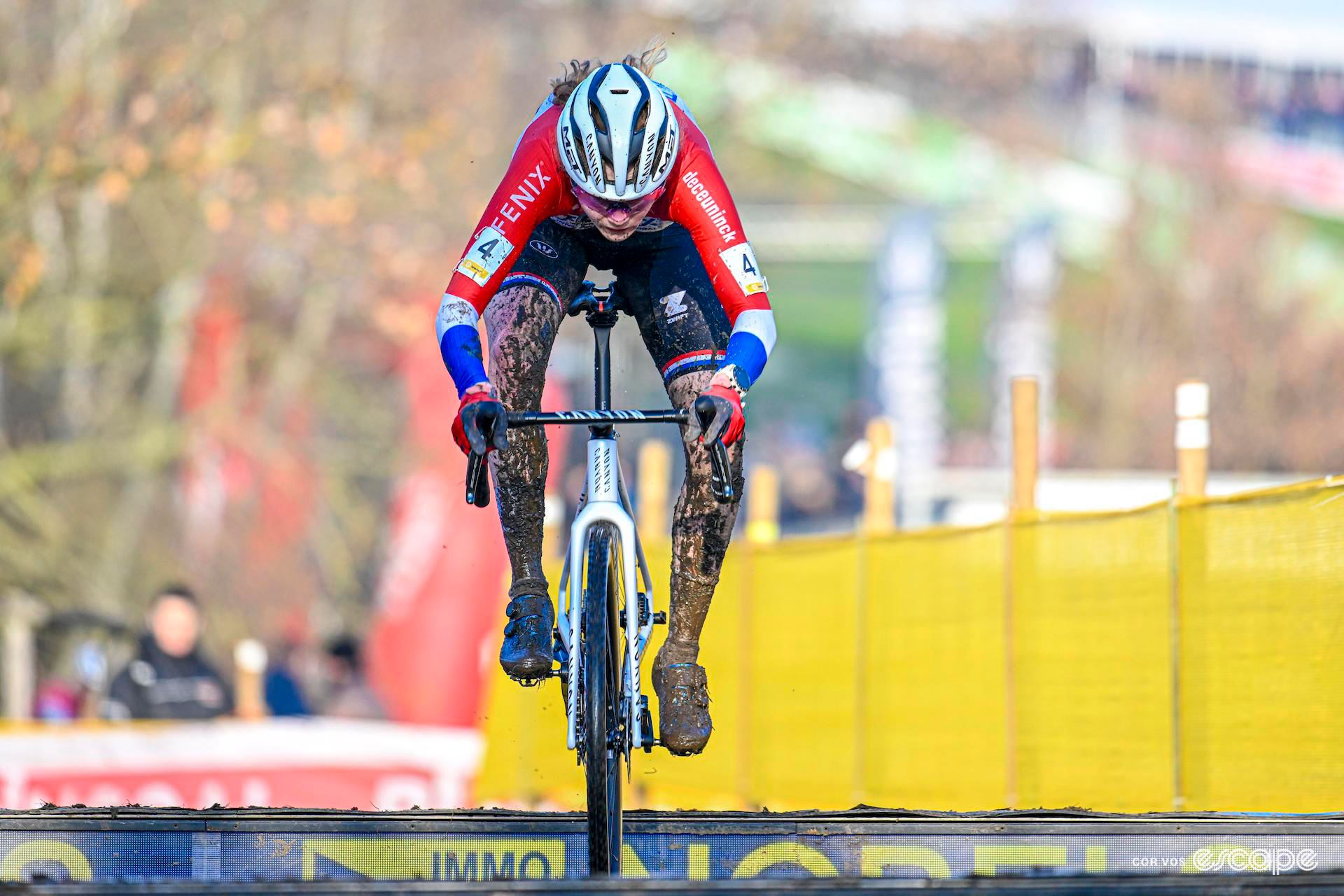 Puck Pieterse, mud splattered and wearing the colours of Dutch national champion, during Cyclocross Superprestige Boom.