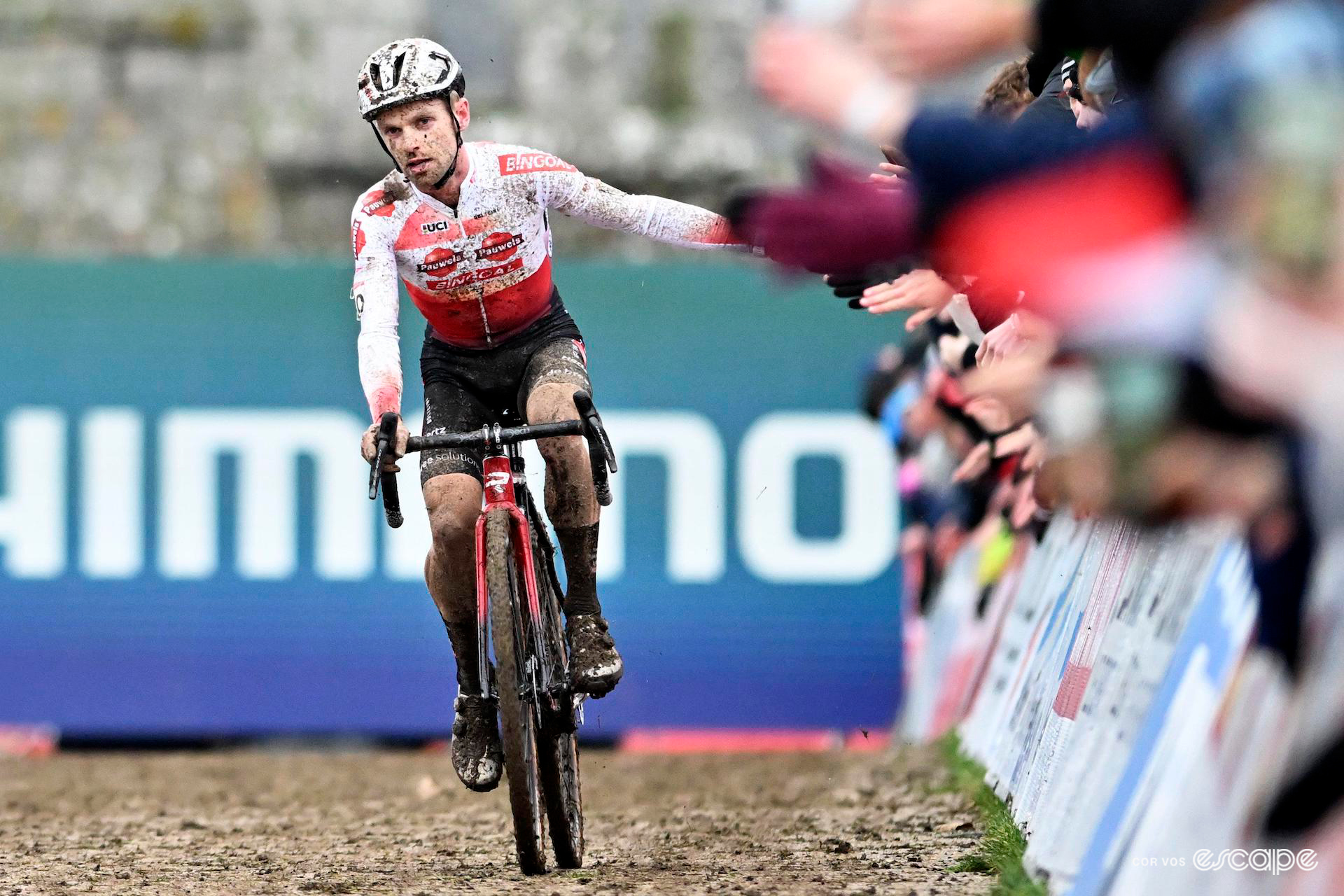 Winner Eli Iserbyt greets the crowd with high fives in the finishing straight of Cyclocross World Cup Flamanville.