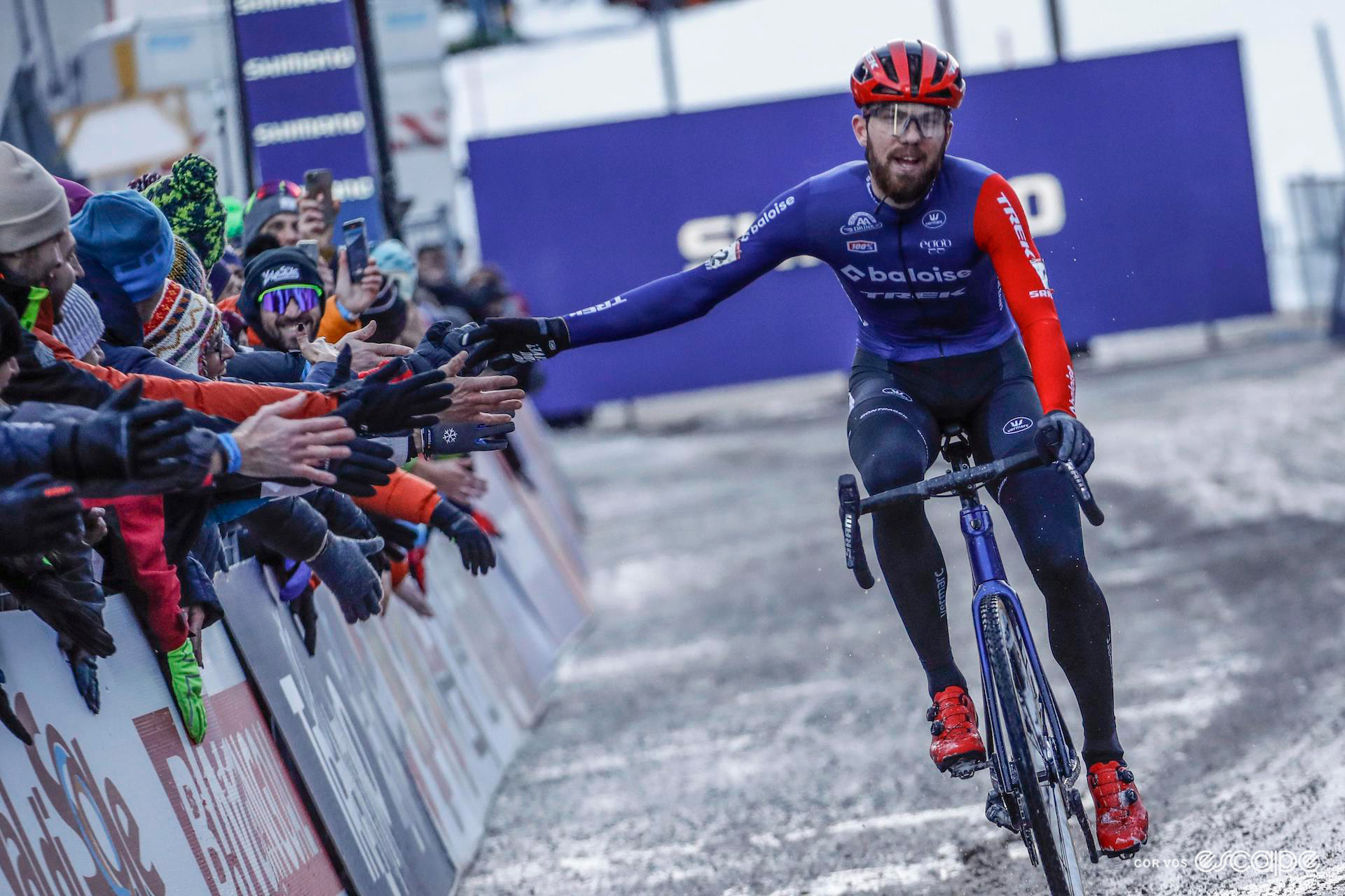 Joris Nieuwenhuis gives high-fives to the crowd as he rides the finishing straight to victory at UCI Cyclocross World Cup Val di Sole.