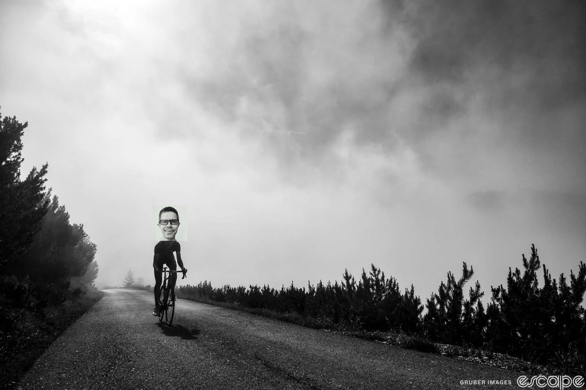 A lone rider climbs a road out of a fogbank. Joe Lindsey's head is geekily pasted atop the rider's body.