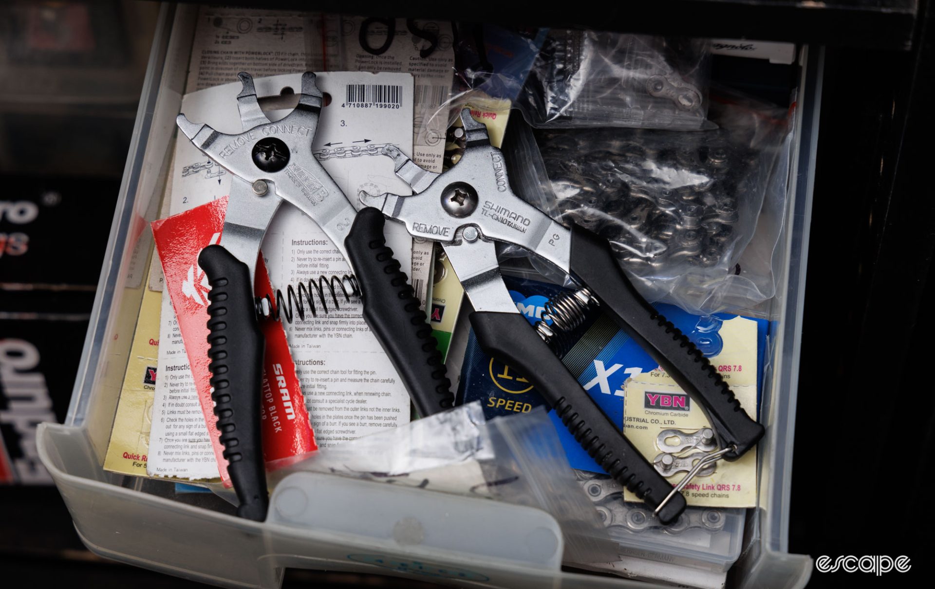 Shimano and Super-B chain link pliers in a drawer with a pile of chain quick links. 