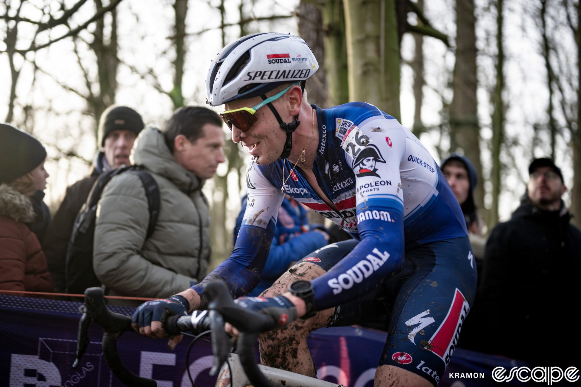 Tim Merlier grins or grimaces as he climbs a muddy section at Gavere.