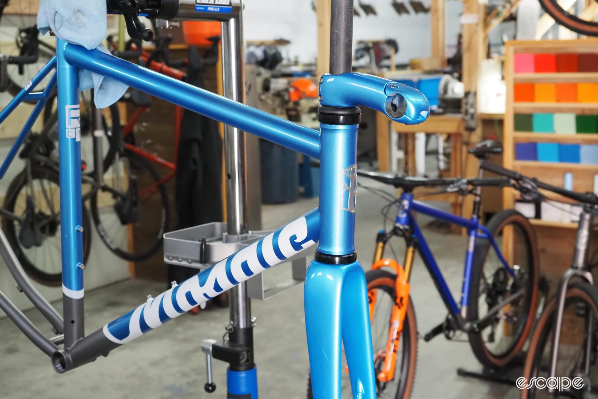 A blue Mosaic frameset sits in a stand ready for final prep.