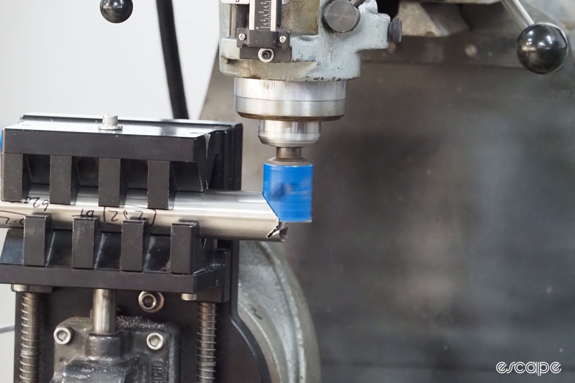 An electric machine tool cuts a precise miter into a titanium frame.