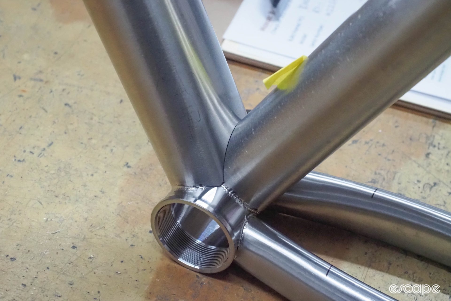 A closeup of the bottom bracket section on a frame, showing a first pass of fusion welds and close miter tolerances on the unwelded portions.