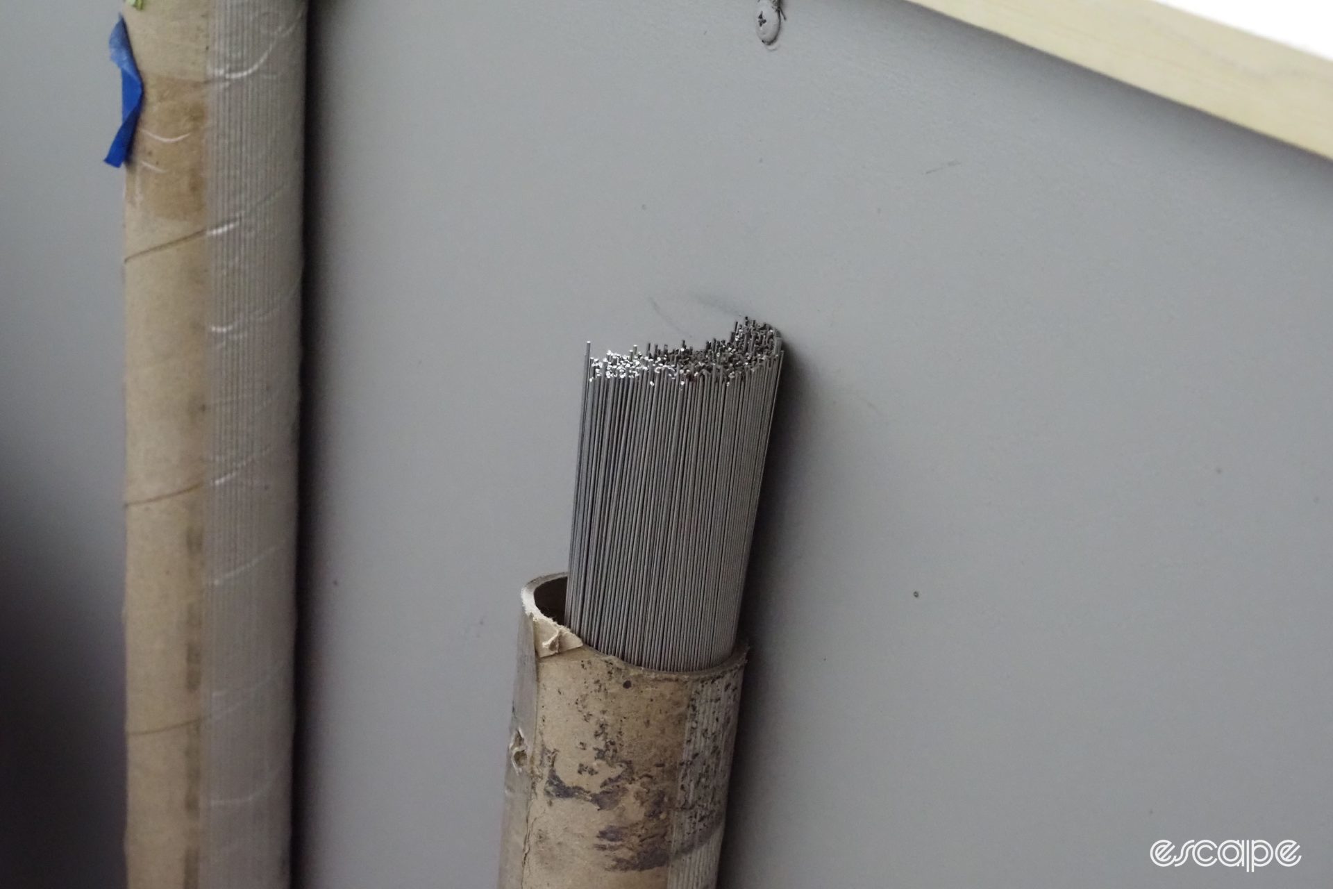 A small neat stack of titanium welding rods in a workstation.