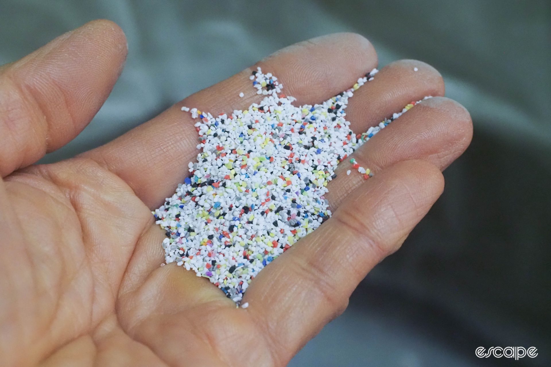 A pile of tiny plastic beads for blasting shown held in someone's hand.