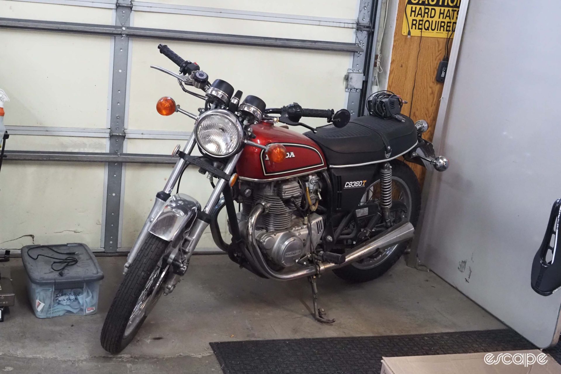 A Honda CB360 motorcycle sits in a corner of the shop.