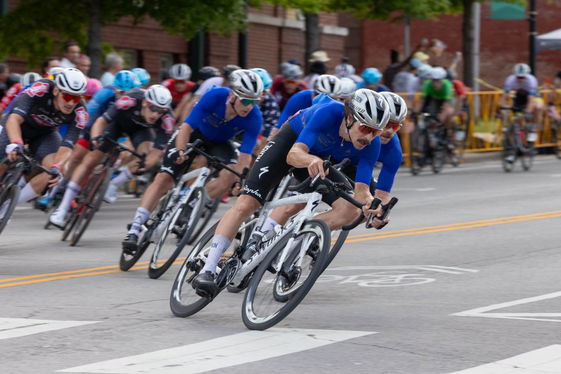 Sam Boardman leads the pack at Tulsa Tough. He's at the front of a line of L39ION riders heading into a corner.