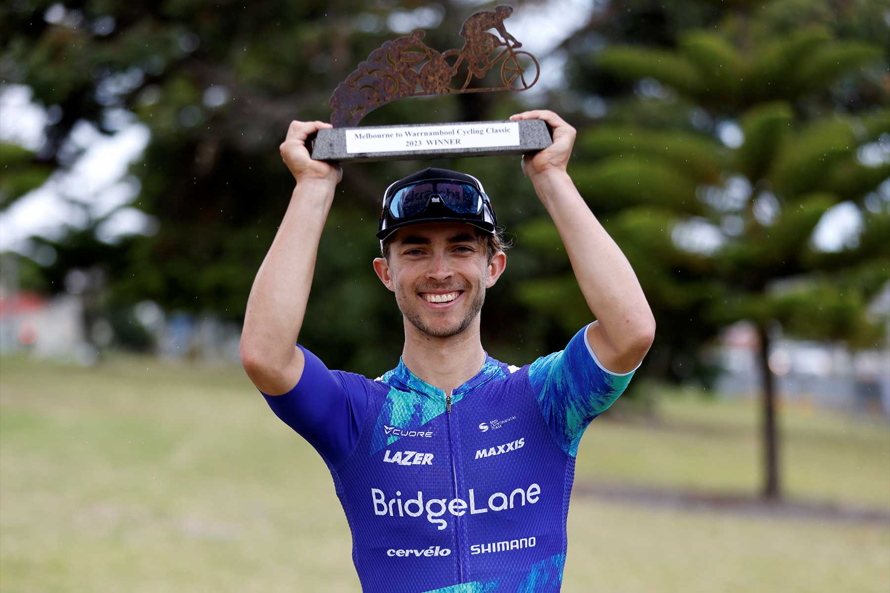 Tristan Saunders holds the 'Warrny' trophy above his head.
