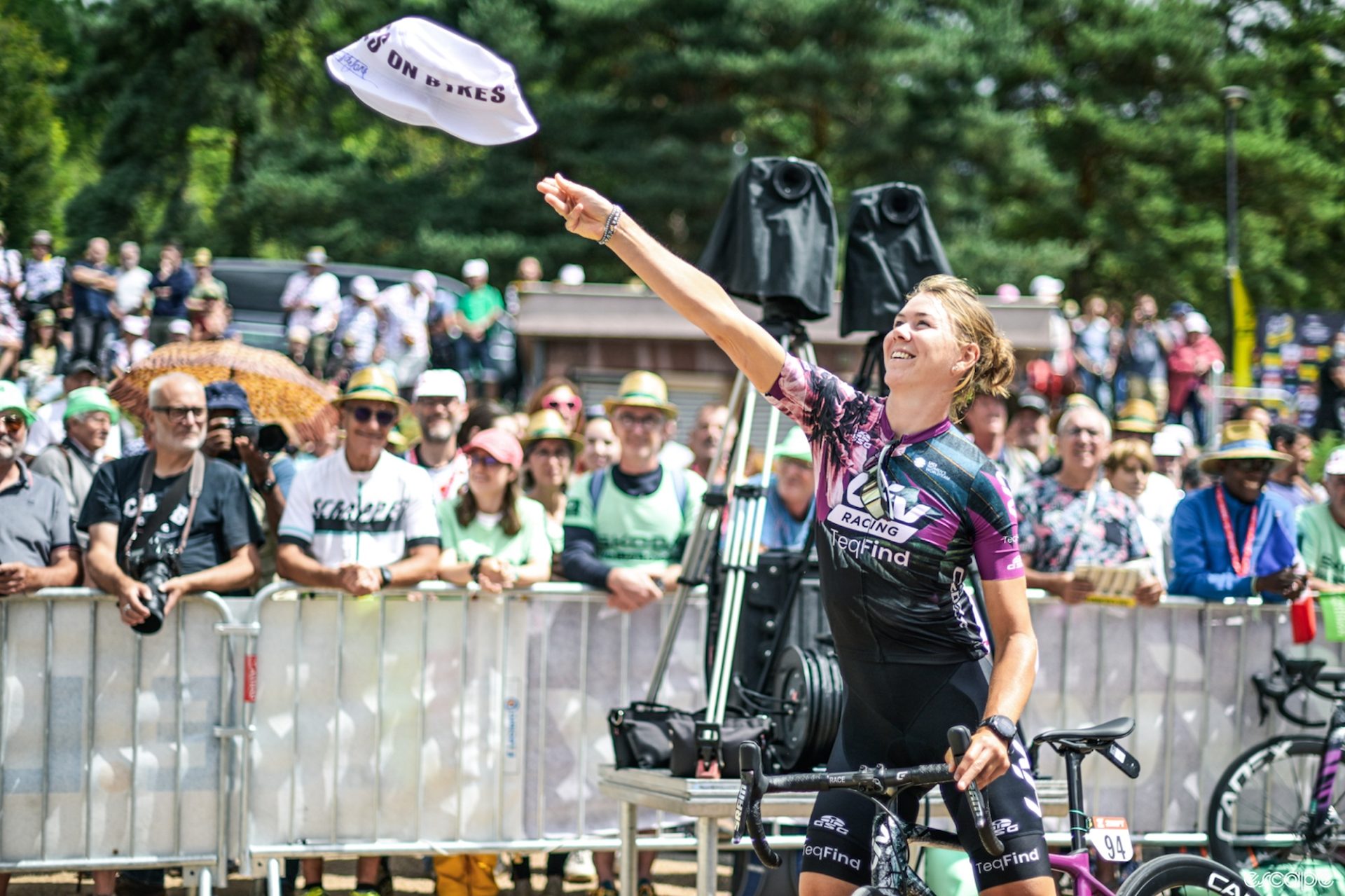 Thalita de Jong at the start of the third stage of the 2023 Tour, throwing a Liv-branded bucket hat into the crowd.
