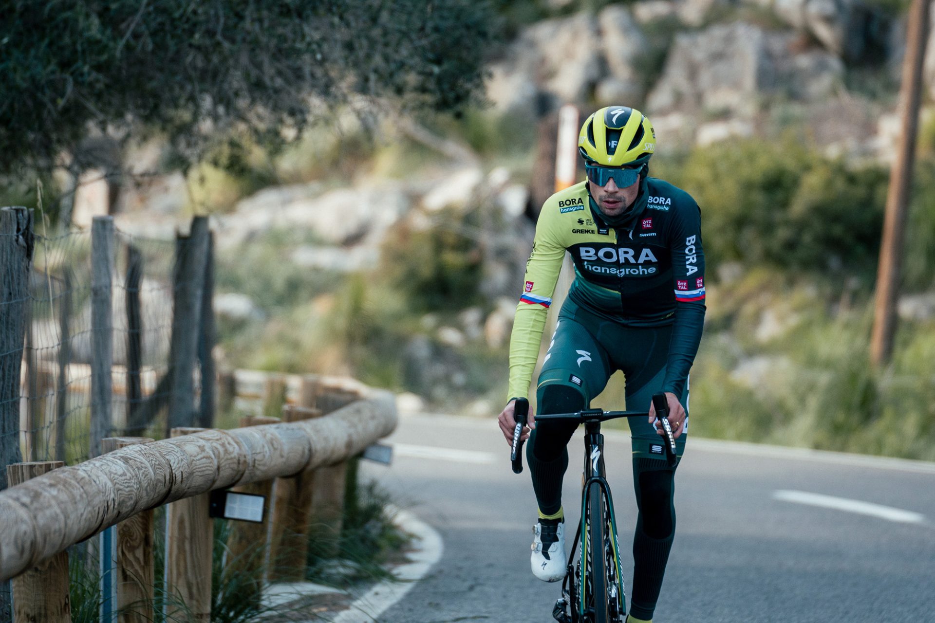 Primož Roglič trains solo. He's pictured bundled up in his new lime and green Bora-Hansgrohe kit, although the blurred landscape behind him suggests Spain rather than Slovenia.