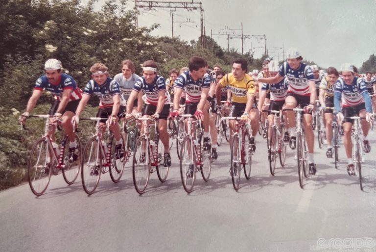 The Americans on Gianni Motta ride at the front of a professional race in Italy in spring 1984. Michael Carter is pictured second from left, and the rider in the yellow Del Tongo jersey laughing with them is 1982 World Champion Giuseppe Saronni. Karl Maxon is the tall rider at Saronni's right.