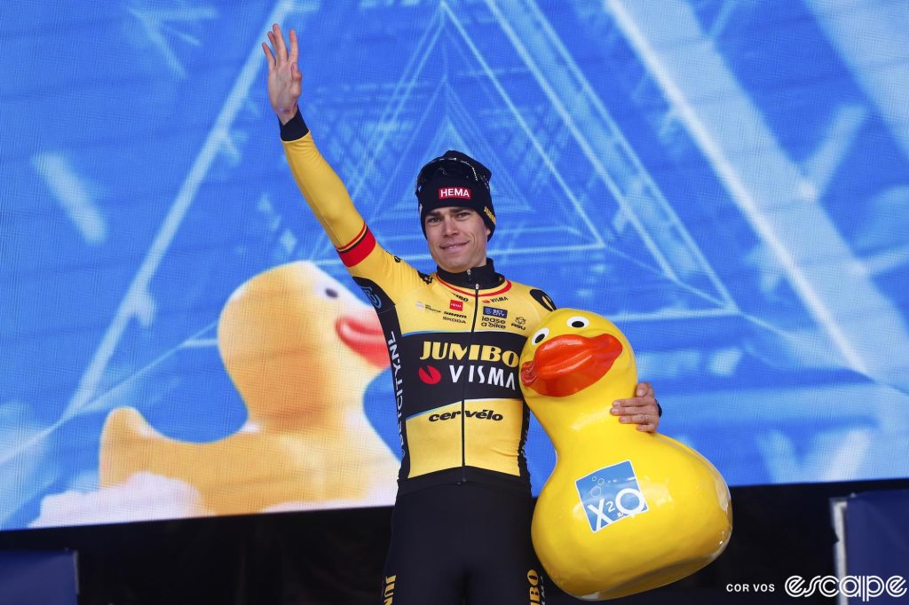 Wout van Aert on the podium of the E3 Saxo Classic with a large rubber duck.