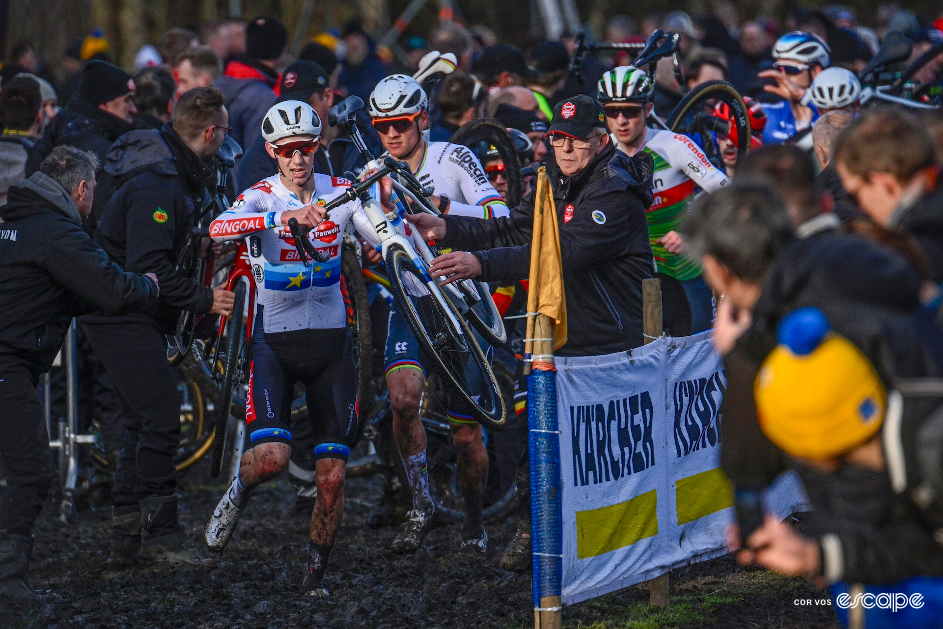 Michael Vanthourenhout leads the elite men out of the pits, bikes held aloft, during X2O Trofee Hamme - Flandriencross.